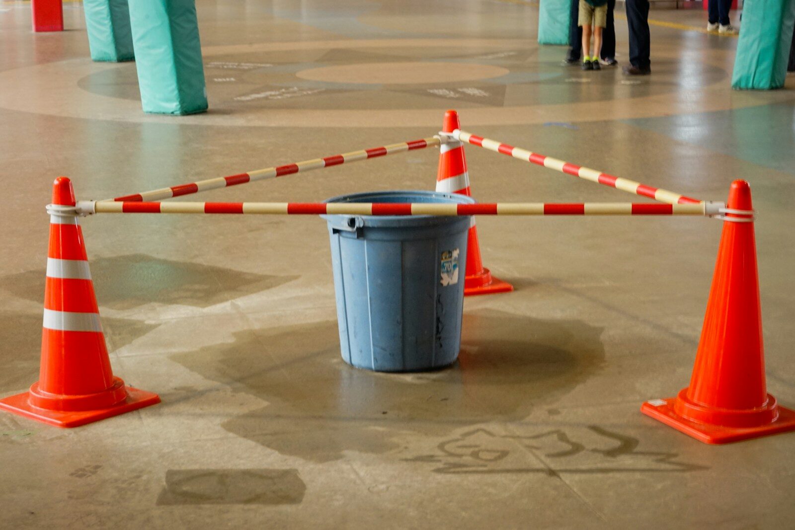 Orange traffic cones with a blue trash can